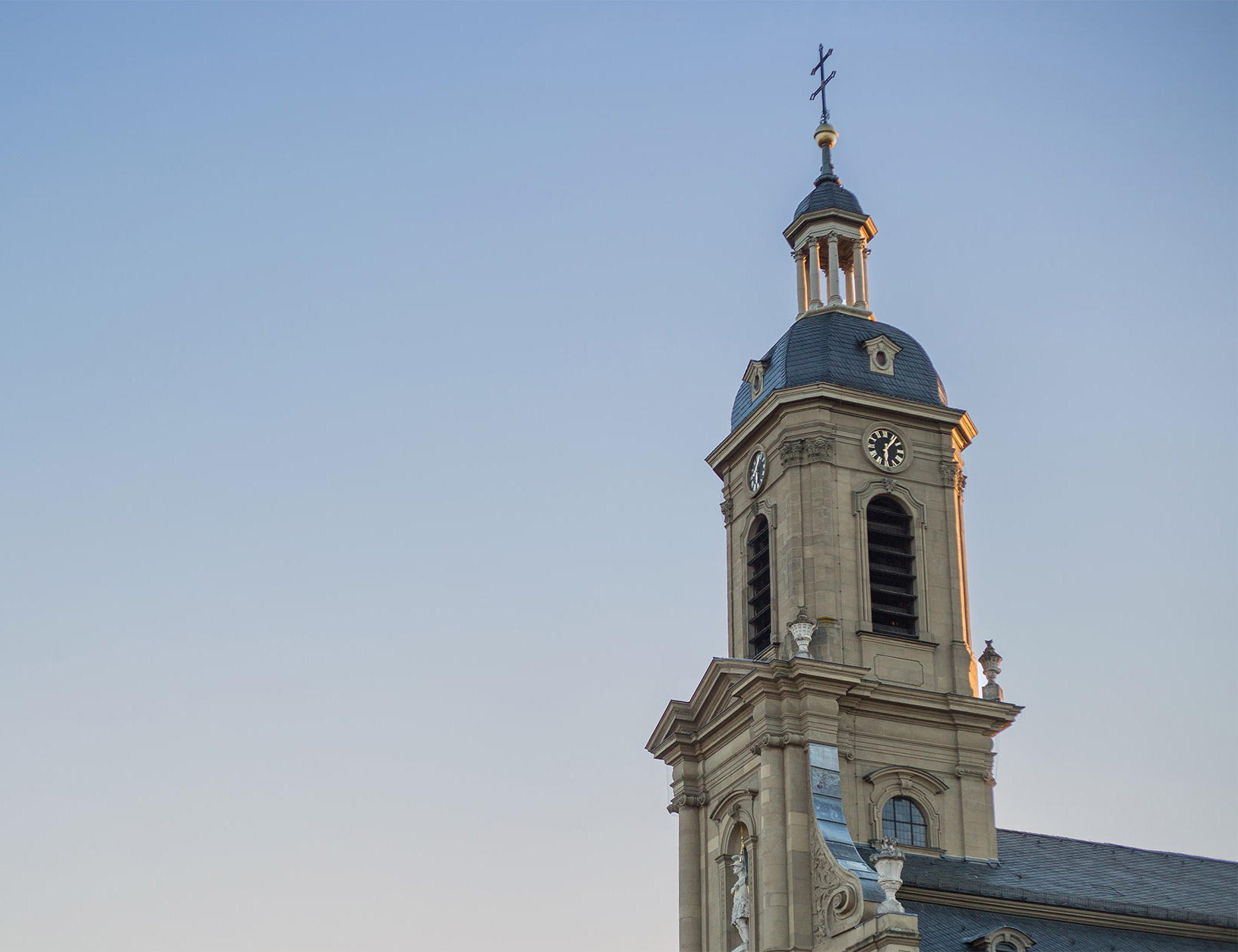 Kath. Kirchengemeinde Kirchturm der St. Mauritiuskirche vor blauem Himmel
