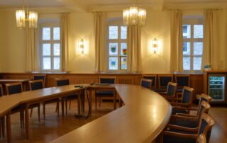 Sitzungssaal Rathaus Wiesentheid runder Holztisch mit Stühlen in einem Raum mit Holzvertäfelung