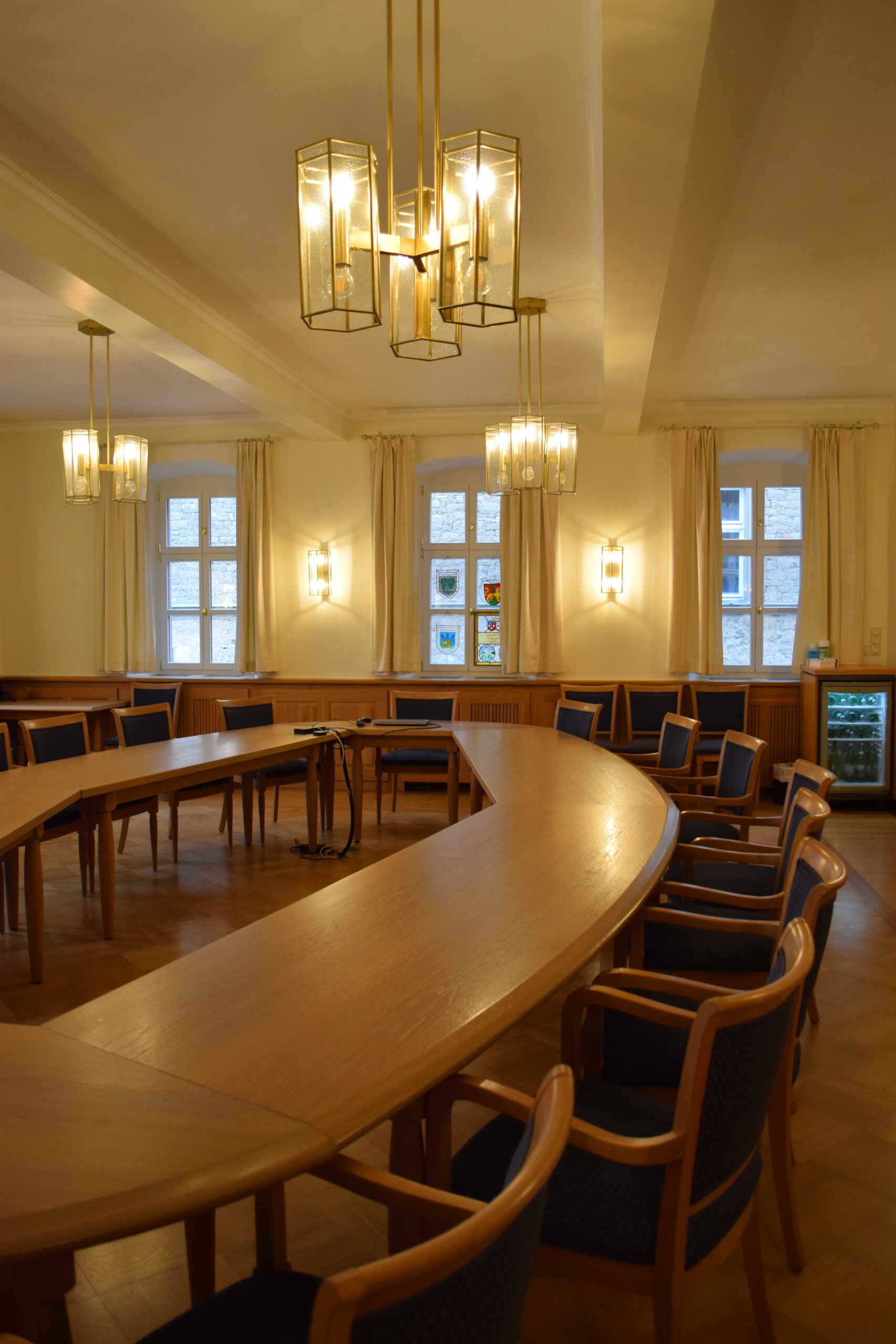 Sitzungssaal Rathaus Wiesentheid runder Holztisch mit Stühlen in einem Raum mit Holzvertäfelung