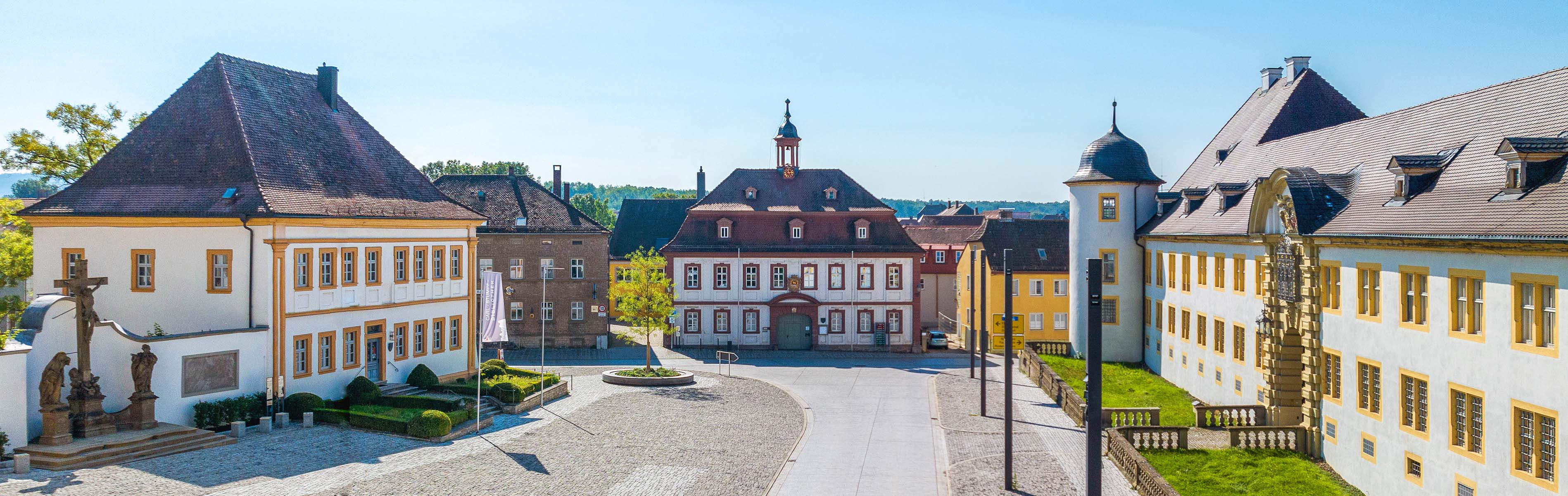 Das Barockensemble Wiesentheid mit drei alten Gebäuden an einem großen Schlossplatz - Pfarrhaus, Rathaus und Schloss
