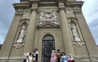 Mauritiuskirche in Wiesentheid mit den Barockdamen und -herren im Vordergrund in barocken Gewändern